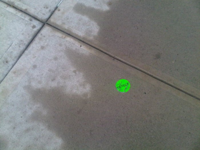 [DEFECT NYC ]© 2011 D.A. Królak. All Rights Reserved.  Sticker on wet NYC sidewalk